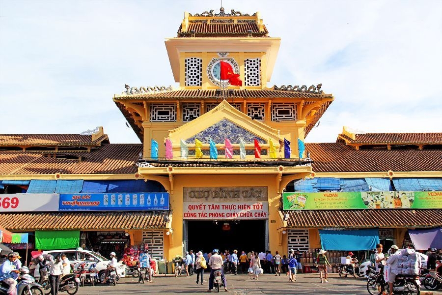 Cổng chính chợ Bình Tây cổ kính với kiến trúc đặc trưng và không gian sầm uất ngày thường